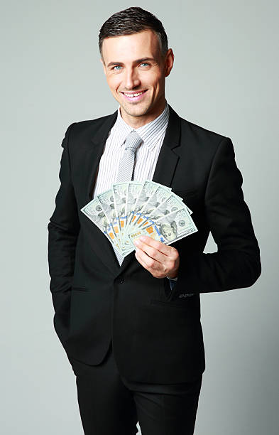 istock businessman holding group of dollar bills 487120577