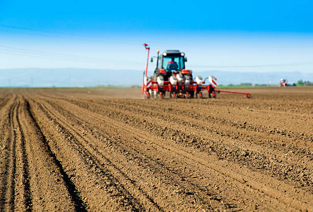istock Farmer in tractor sowing crops at field 487123867