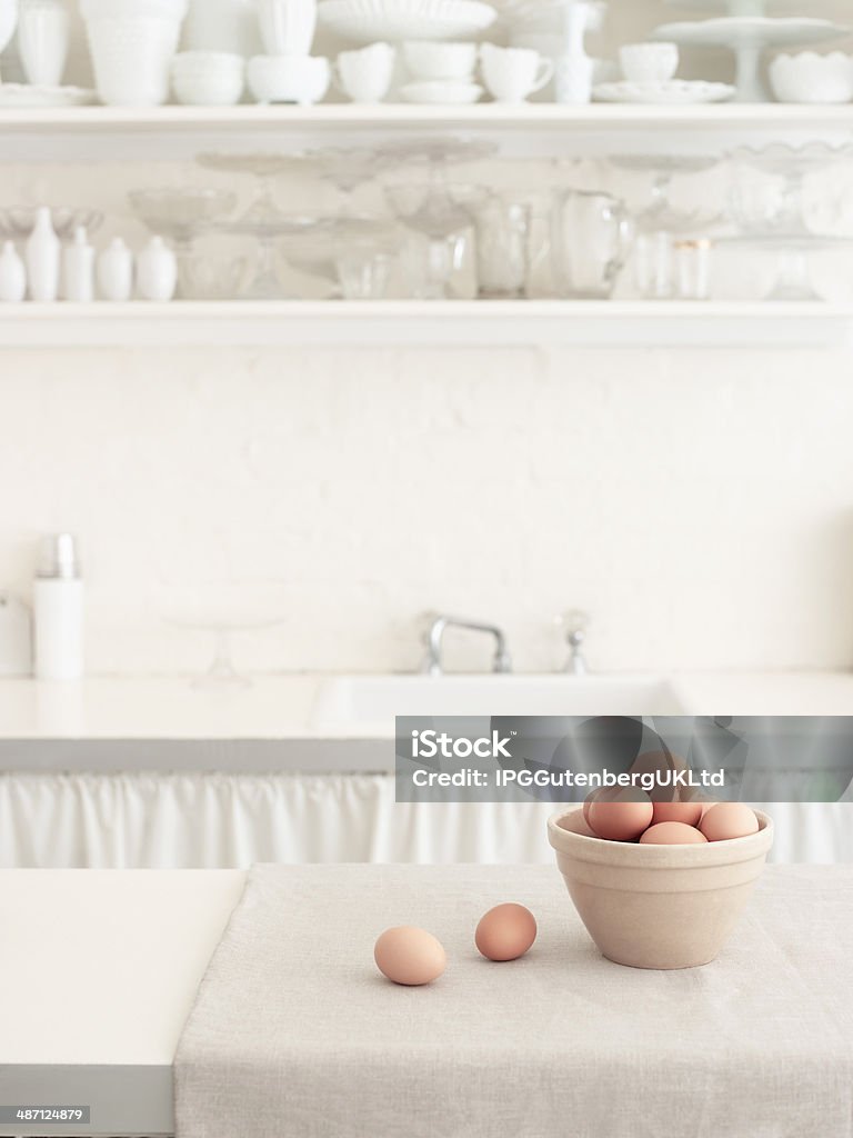 Brown Eggs In a bowl Basket of brown eggs on countertop with bowls on shelf in white kitchen Arranging Stock Photo