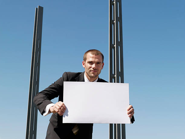 istock Businessman Holding Blank Sheet By Concrete Pillars 487126389