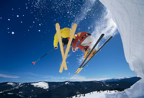 istock Skiers Launching Off Snow Bank Hitting The Slopes 487126431