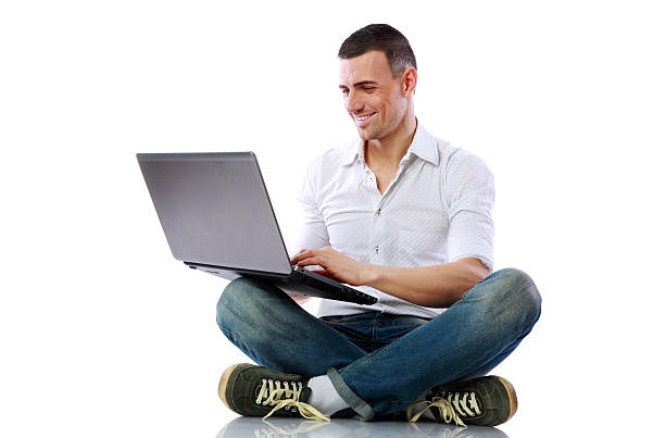 istock Smiling man sitting at the floor with laptop 487126545