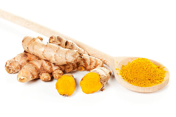 istock Turmeric roots and powder on spoon 487127865