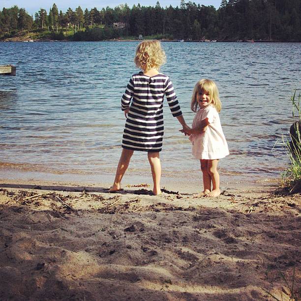 две девочки, изучение шведский архипелаг - sibling sweden family smiling стоковые фото и изображения