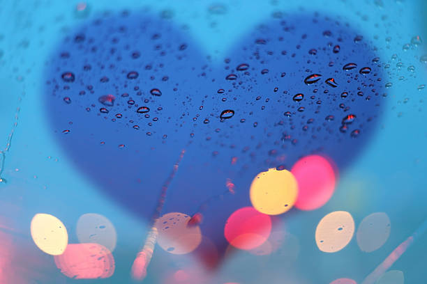 istock Rain drops on window with light bokeh and heart frame. 487131190