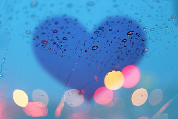 istock Rain drops on window with light bokeh and heart frame. 487131196