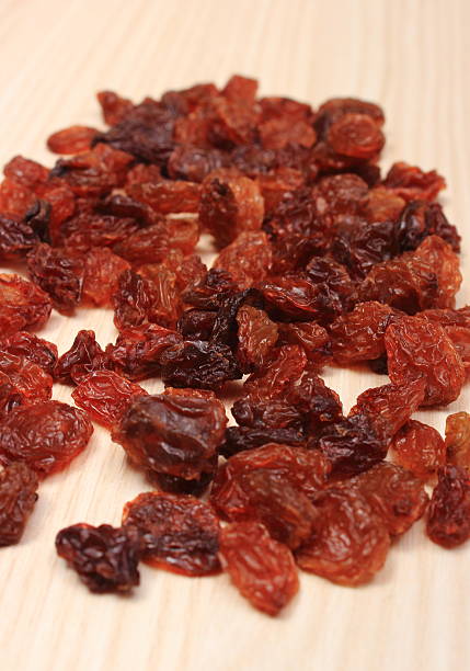 istock Brown raisins on wooden table, healthy eating 487131924