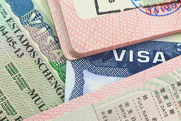 Chinese, USA and Shengen European visas in passports - adventure background