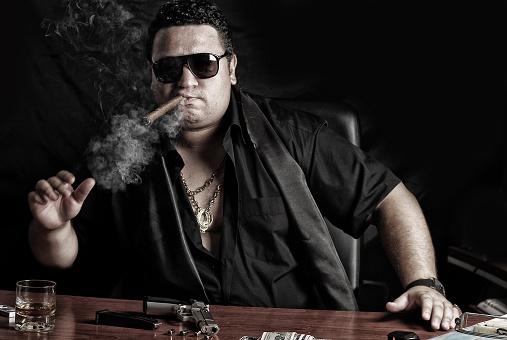 Gangster Man is smoking cigar and he have money.
