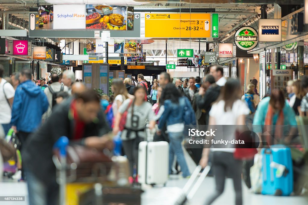 Airport crowds in Europe Color image of people walking in the terminal at Schiphol International Airport in the Netherlands. Selective focus on background with copy space. Amsterdam Schiphol Airport Stock Photo