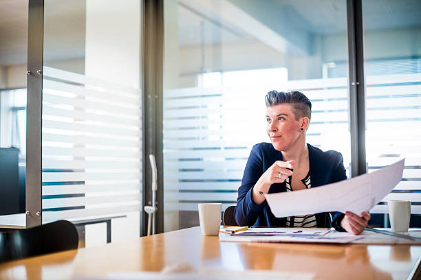 istock Businesswoman holding document at conference table 487134444