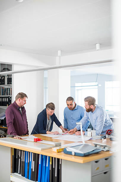 istock Business team analysing blueprint together at desk 487134448