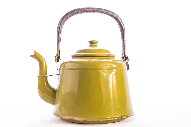 Antique enamelware teapot including dents and scratches and even some rust spots.  Horizontal format on white background with copy space.