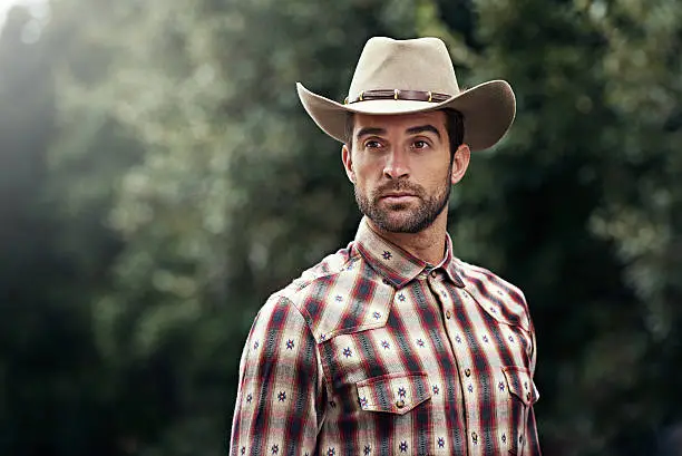 Shot of a handsome cowboy wearing a check shirt and stetsonhttp://195.154.178.81/DATA/i_collage/pi/shoots/784125.jpg