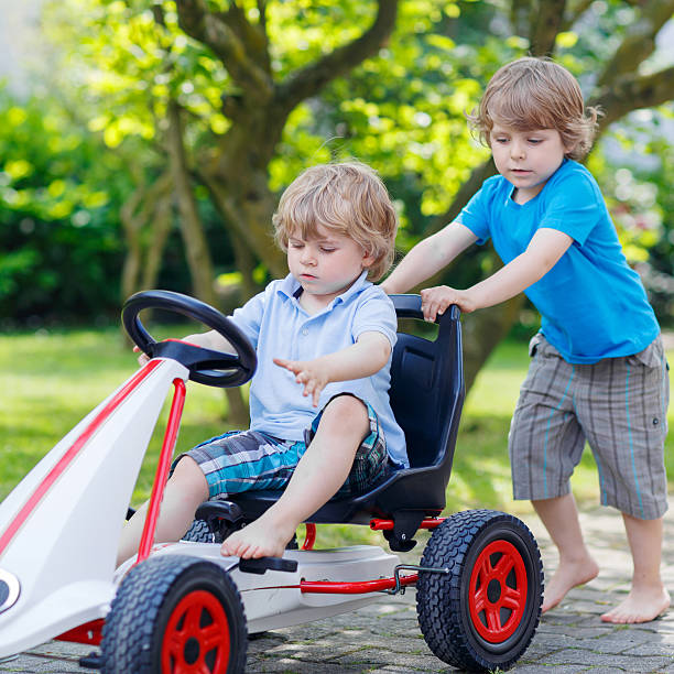 istock Two happy sibling boys having fun with toy car 487145338