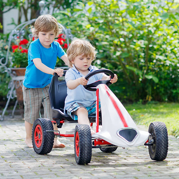 istock Two happy kid boys having fun with toy car 487145342