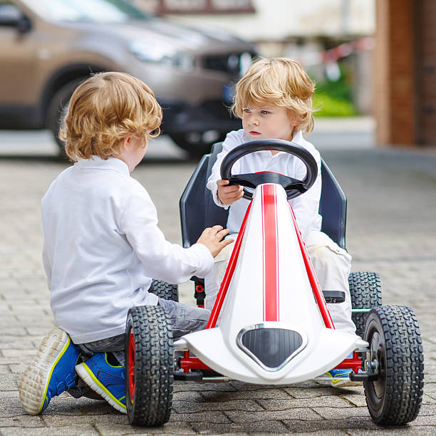 istock Two happy sibling boys playing with toy car 487145348