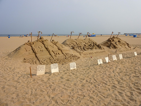 Ocean City, USA-September 2, 2015:  This sand sculpture was spotted at the beach in Ocean City Maryland.  It is promoting a religious message of love.  This type of artwork takes many hours to complete and is temporary depending upon the weather.