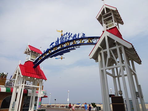 Ocean City, USA-September 2, 2015:  This entrance to the Boardwalk was spotted in Ocean City Maryland.  This is at N Division Street and is the main entrance.   The boardwalk features restaurants, clothing stores, arts and crafts as well as amusement park rides.  The beach and Atlantic ocean are in the background.