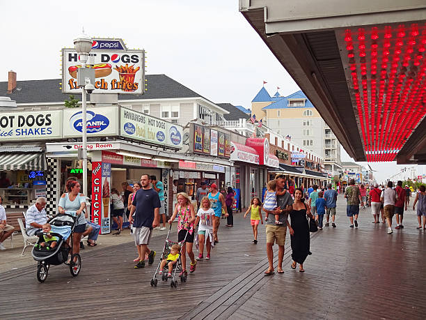 Ocean City, USA-September 2, 2015:  These people were spotted at the Boardwalk in Ocean City Maryland. They are walking to purchase food or goods or take one of the rides here. The boardwalk features restaurants, clothing stores, arts and crafts as well as amusement park rides.  This is the busiest part of downtown Ocean City Maryland.