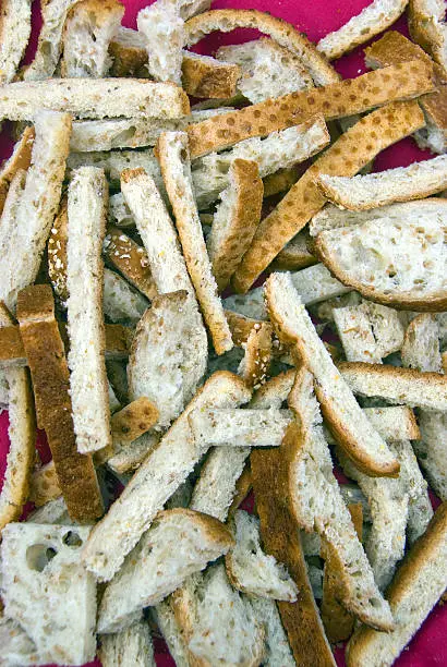 Crusts of bread cut-off and laying on a magenta background.