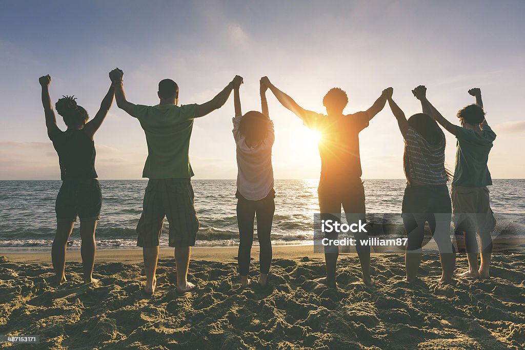 Multirracial grupo de pessoas com os braços levantados na procura de pôr do sol - Royalty-free De Mãos Dadas Foto de stock