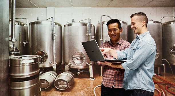 lavoratore utilizzando computer portatile in un buon pianta - bottling plant brewery industry food foto e immagini stock