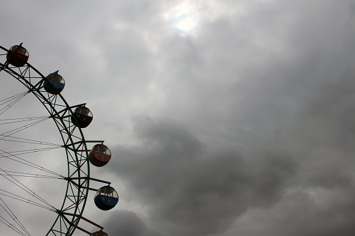 Background amusement park Ferris wheel has turned into a cloudy sky.