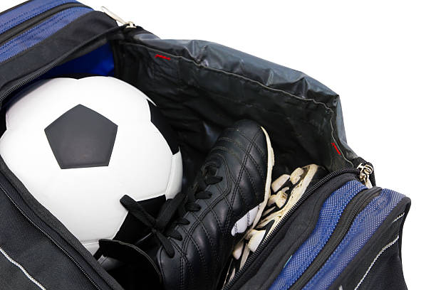 football and soccer boots in bag stock photo