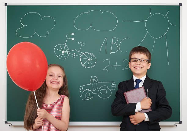 istock school boy and girl draw on board 487156686