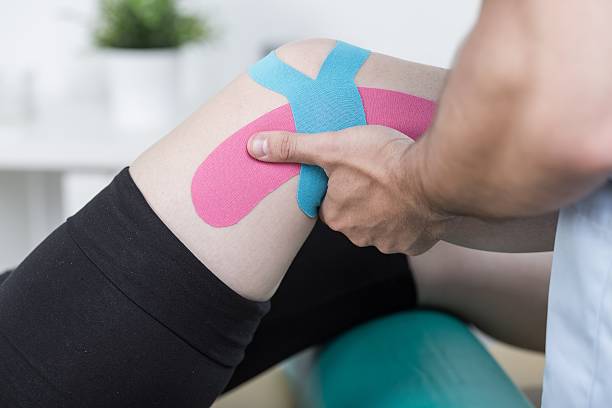 paciente después de la lesión de la rodilla - kinesio fotografías e imágenes de stock