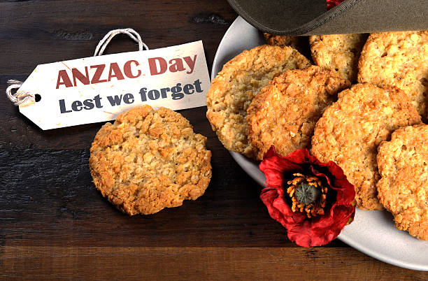 Australian army slouch hat and traditional Anzac biscuits Australian army slouch hat and traditional Anzac biscuits on dark recycled wood with remembrance red poppy with Anzac Day, Lest We Forget tag. corn poppy photos stock pictures, royalty-free photos & images