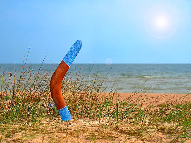 bumerang auf überwachsen sandstrand. - australia boomerang aboriginal aborigine stock-fotos und bilder