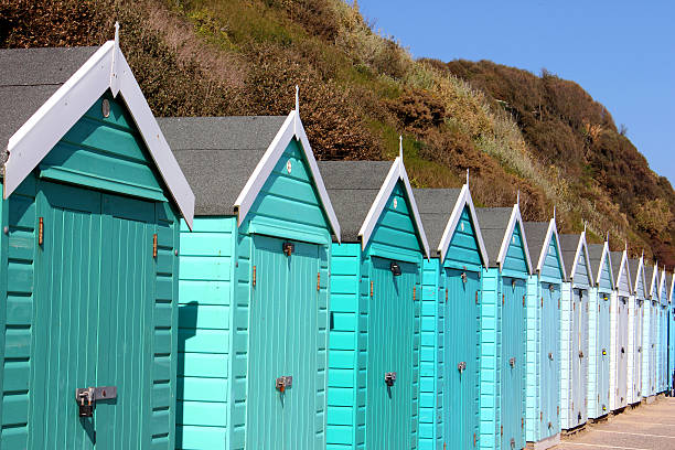 istock Image of colourful English painted beach huts next to cliff 487158985
