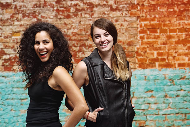 istock Two cheerful women in front of brick wall 487160533