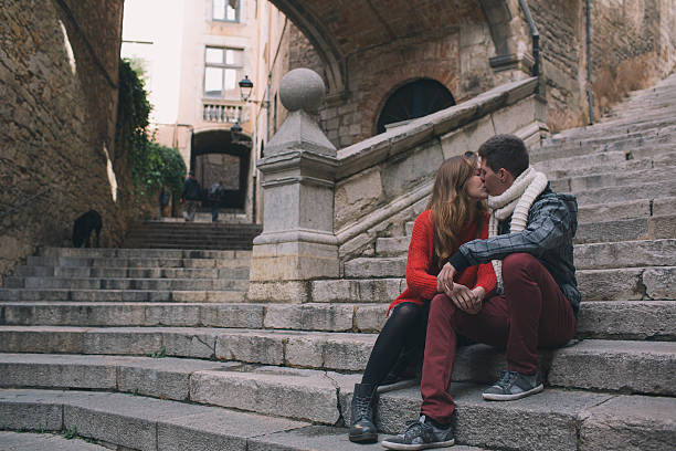 Young couple kissing under the arches in old city of Girona
