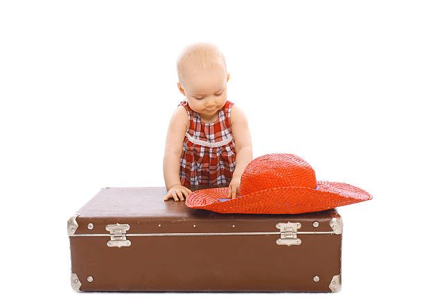 istock Child with straw summer hat and suitcase on a white 487168366