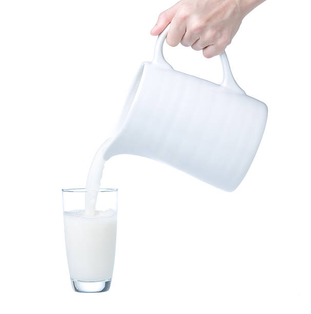 istock Pouring fresh milk from pitcher into glass 487168430