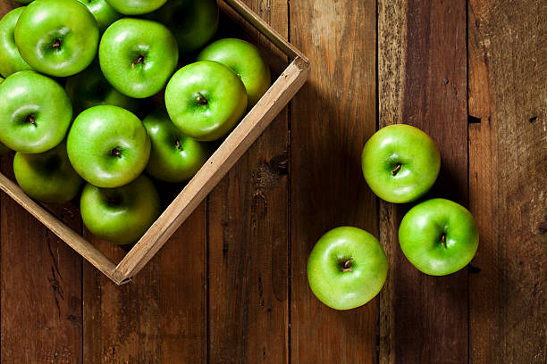 istock Green apples on rustic wood table shot directly above 487171262