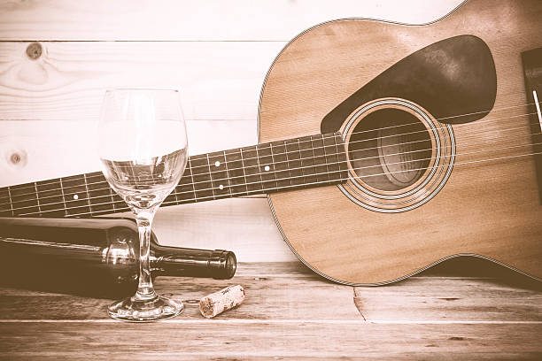 vintage Guitar with wine bottle and glass on the old wood floor.