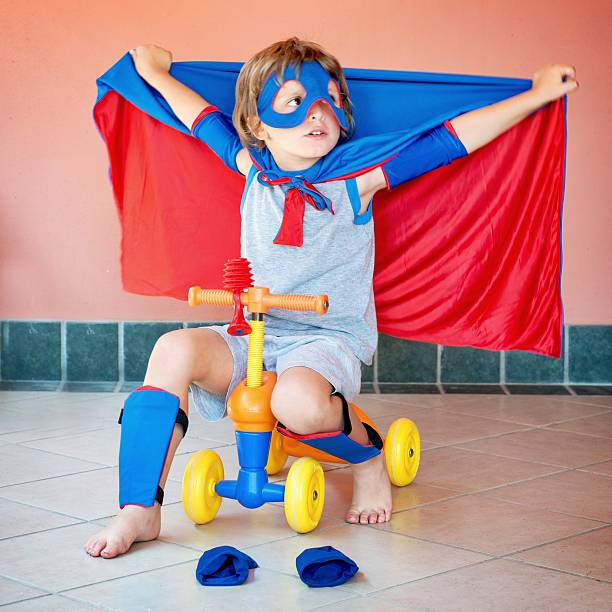 istock Little Superhero Riding a 4 Wheels Toy Vehicle 487172874