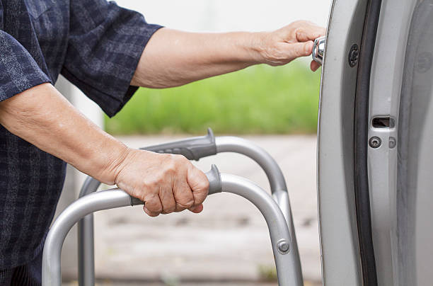 istock senior woman using a walker at car park 487173184