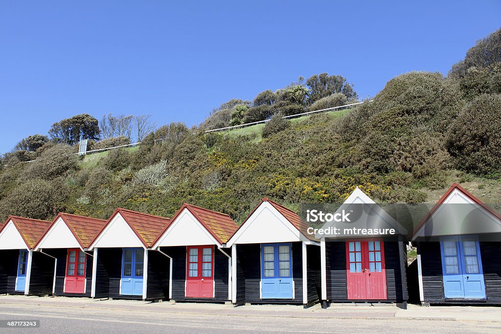 Immagine di colorate dipinte inglese spiaggia capanne vicino alla scogliera - Foto stock royalty-free di Baracca - Struttura edile