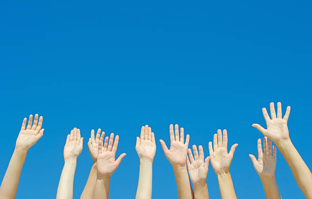 istock Many hands raised up against the blue sky. 487174133