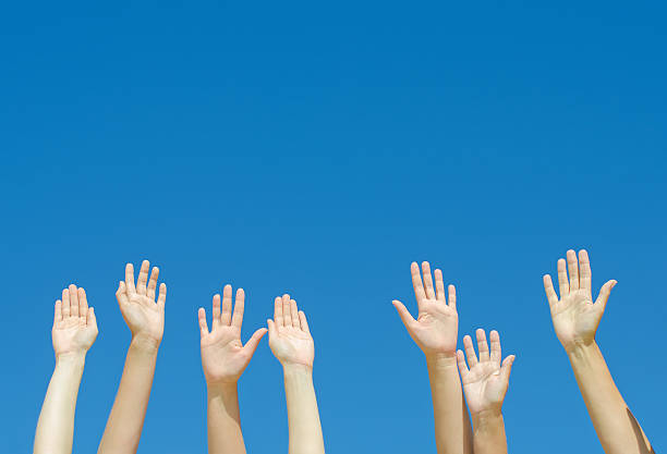 istock Many hands raised up against the blue sky. 487174135
