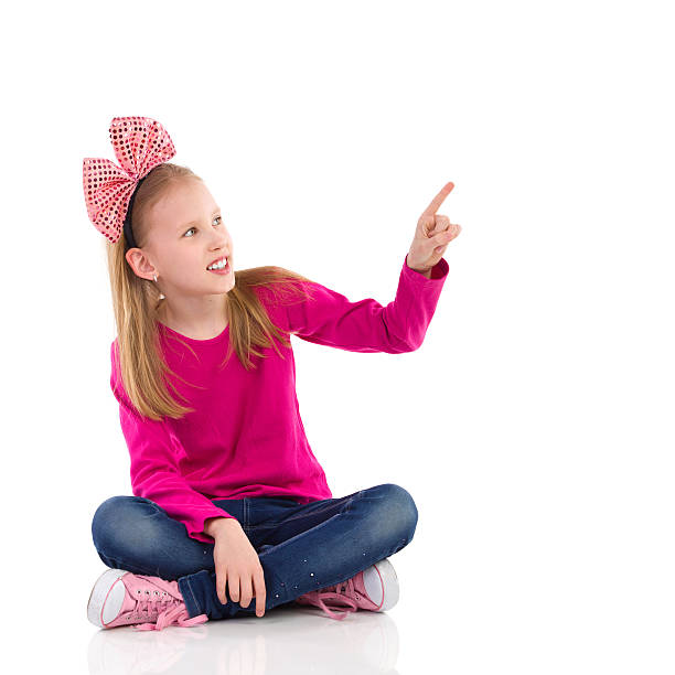 istock Little girl with hair bow pointing 487174309