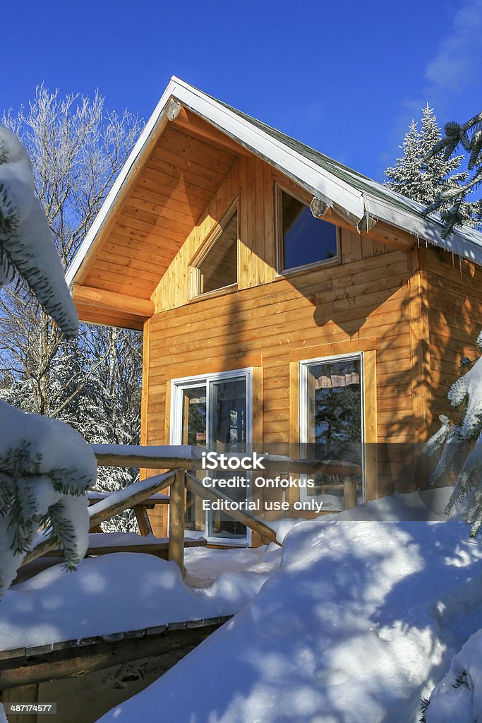 Wooden Cottage, Log Home, Log Cabin in Winter St-Raymond, Canada - December 30, 2007: Wooden chalet at the summit of an hiking and snowshoeing trail, Vallee du bras du nord, Quebec, Canada. Architecture Stock Photo