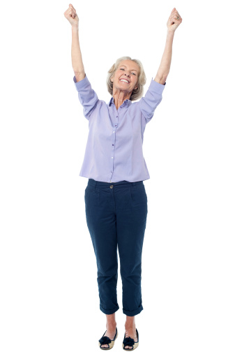 Excited senior citizen raising her hands
