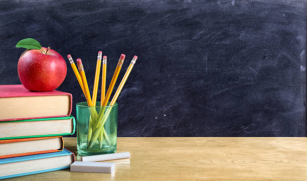una mela su libri con matite e lavagna vuota - blackboard desk classroom education foto e immagini stock