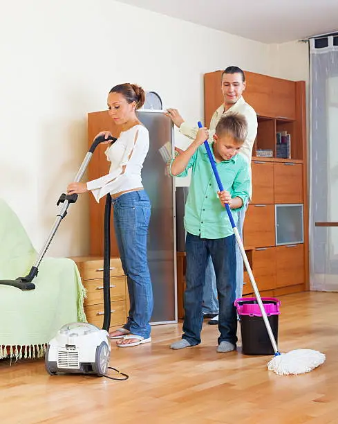 Ordinary family of three vacuuming together